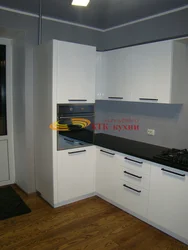 Photo of a kitchen with a right corner and a refrigerator