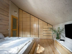 Bedroom in the attic of a wooden house with a sloping ceiling photo