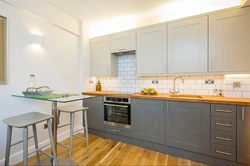 Gray kitchen with a wooden countertop and a wood-effect apron photo