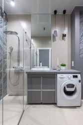 Photo of a small bathroom with shower and washing machine