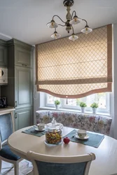 Roman blinds in the kitchen interior with tulle