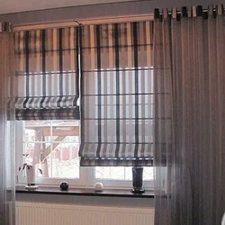 Roman blinds in the kitchen interior with tulle