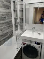Bathtub and washing machine in a small bathroom photo