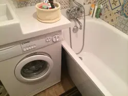 Bathtub and washing machine in a small bathroom photo