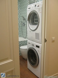Washer and dryer in a column in the bathroom interior