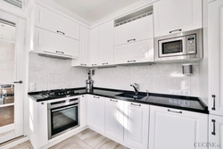 Kitchen with black handles in a white interior