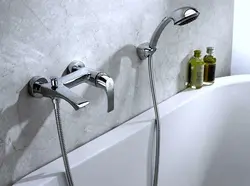 Photo of a faucet in a bathroom with a shower