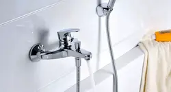 Photo of a faucet in a bathroom with a shower