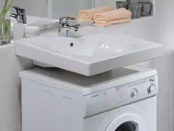 Photo of a washing machine under the sink in the bathroom