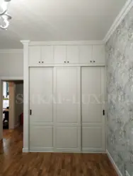 Wardrobe to the ceiling with hinged doors in the hallway photo