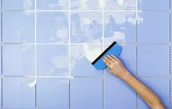 Grouting tiles in the bathroom photo