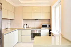 Beige kitchen design with black splashback
