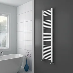 White heated towel rail in the bathroom interior