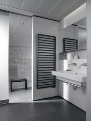 White heated towel rail in the bathroom interior