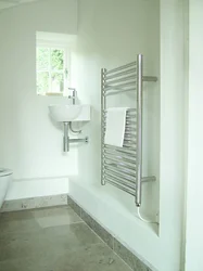 White heated towel rail in the bathroom interior