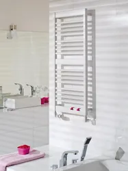 White heated towel rail in the bathroom interior