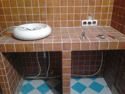 Тахтачаи сафолӣ дар ҳаммом дар зери акси раковина