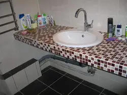 Tile countertop in the bathroom under the sink photo