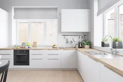 Corner white kitchen with wooden countertop photo in the interior