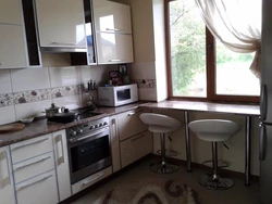 Design of a small kitchen with a refrigerator by the window