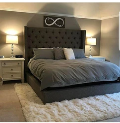 Gray bed with a soft headboard in the bedroom interior photo