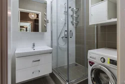 Bathroom with shower and washing machine with sink photo