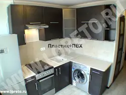 Үстелдің бұрышындағы фотосуреттің астындағы кір жуғыш машинасы бар ас үйлер