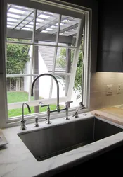 Kitchen design by the window with a sink in the apartment