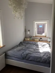Bed against the wall photo design in a small bedroom