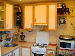 Photo of a small kitchen with a window and a column