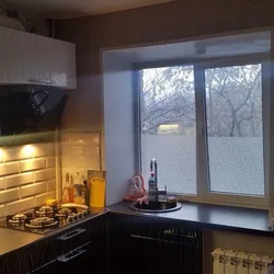 Photo of a small kitchen with a window and a column