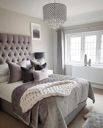 Bedroom design with a gray bed with a soft headboard