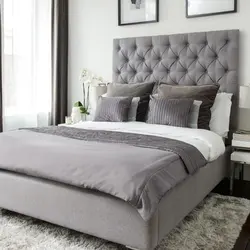 Bedroom design with a gray bed with a soft headboard