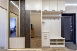 Design of a narrow hallway in an apartment with a wardrobe in a modern