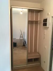 Design of a narrow hallway in an apartment with a wardrobe in a modern