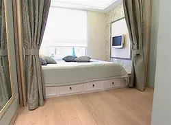 Double bed by the window in a small bedroom photo