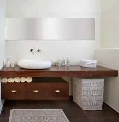 Photo of a bathtub with a sink and a bedside table in the bathroom