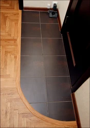 Tiles at the entrance door in the hallway and laminate photo
