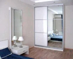 Photo of a wardrobe in the bedroom with a mirror for three doors