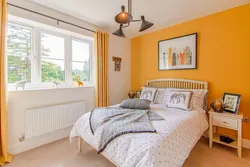 Orange wallpaper in the bedroom interior