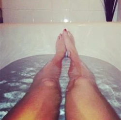 Photo of women's legs in the bathroom