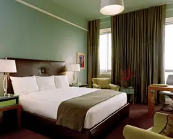 Green color of curtains in the bedroom interior