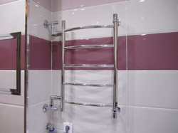 Heated towel rail photo in the bathroom in the apartment