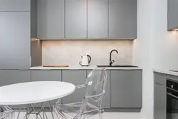 Kitchen with a gray countertop in a white interior and an apron