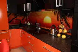 Orange-black kitchen in the interior photo