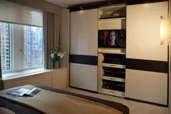 Sliding wardrobes with a niche for a TV in the bedroom photo