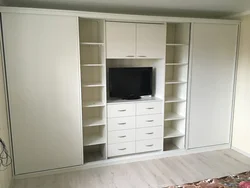 Yotoqxonadagi fotosuratda televizor uchun joy bilan toymasin shkaflar