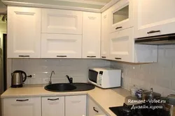 Oq stol usti va qora lavabo bilan oshxonaning fotosurati