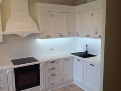 Photo of a kitchen with a white countertop and a black sink