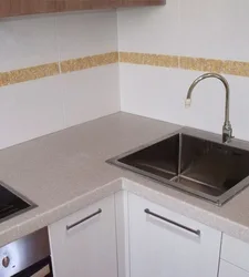 Акси ошхона бо countertop сафед ва танӯраи сиёҳ